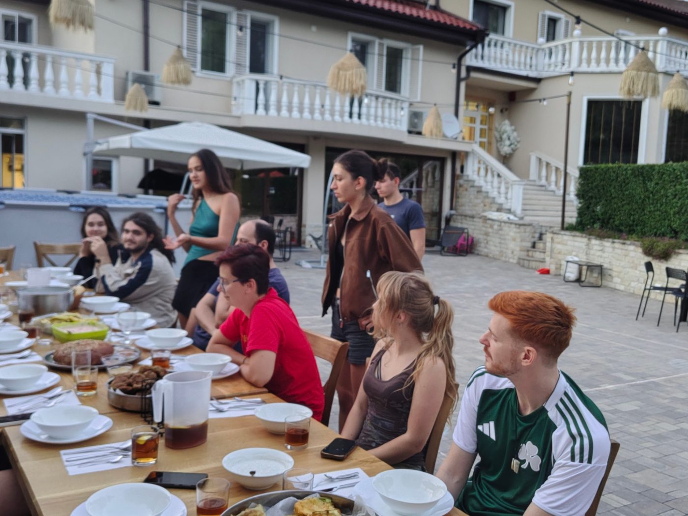 Participants gather around the table for an evening meal in the garden