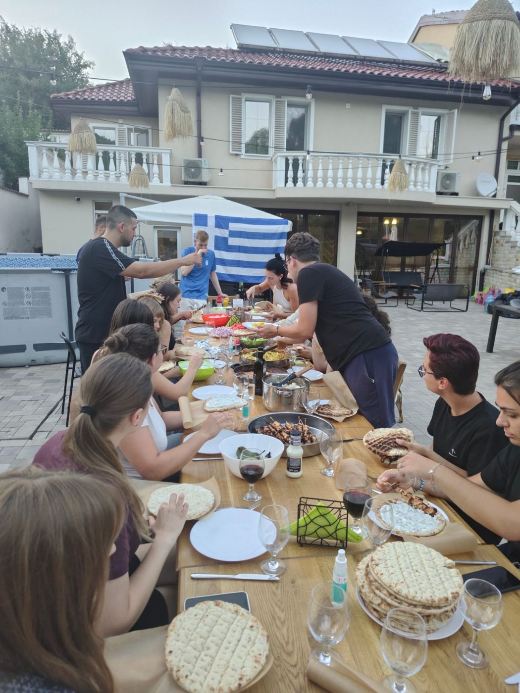Dinner in the garden under the Greek flag, with pitas, skewers and tzatziki