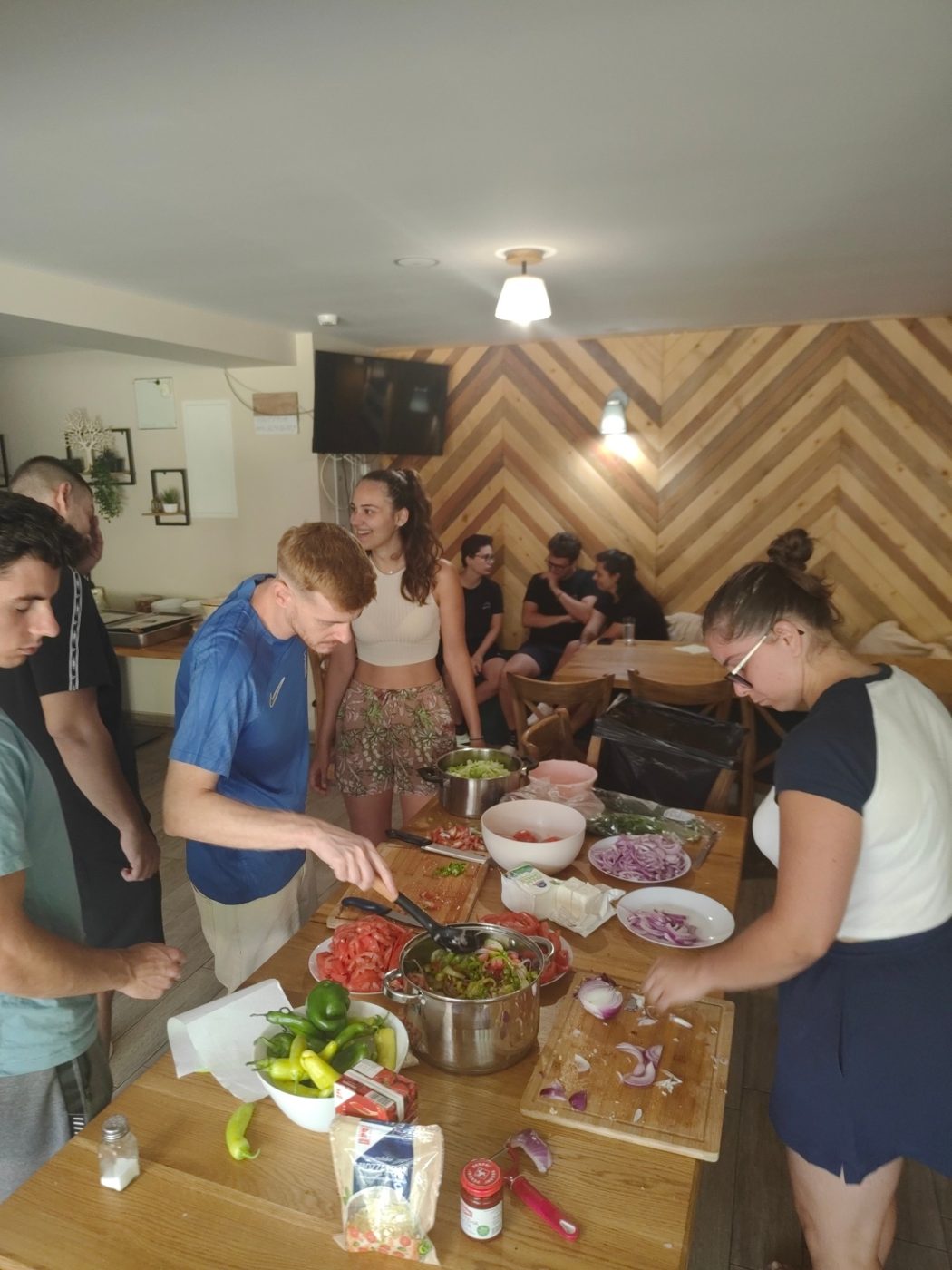 Participants chop tomatoes, onions and peppers at a cooking station