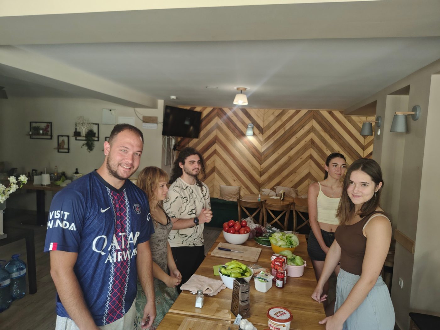A team with fresh tomatoes, peppers and lettuce, ready to start cooking