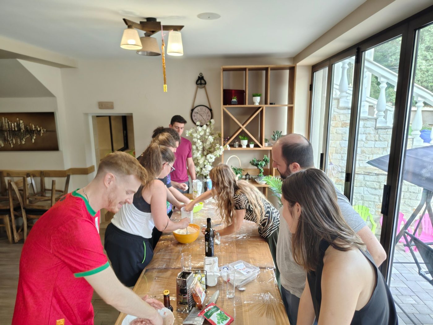 Participants knead dough together at the long table