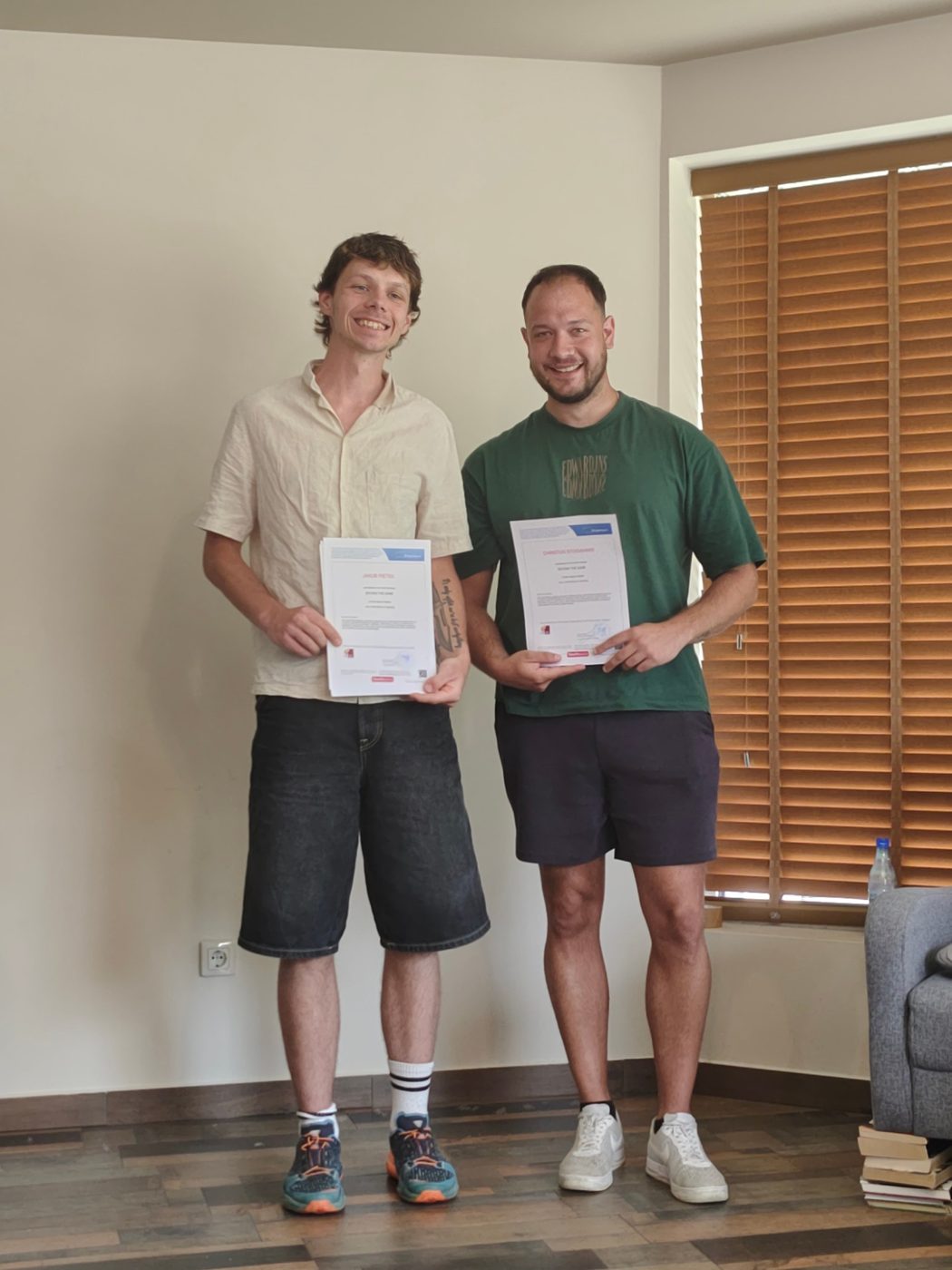 Two smiling participants holding their Youthpass certificates