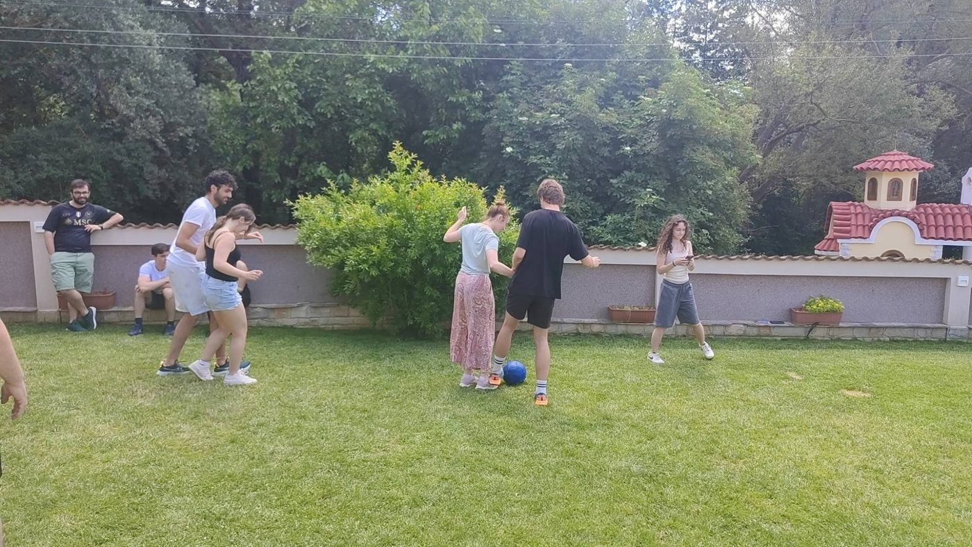 Pairs tied together at the ankles try to dribble the ball together