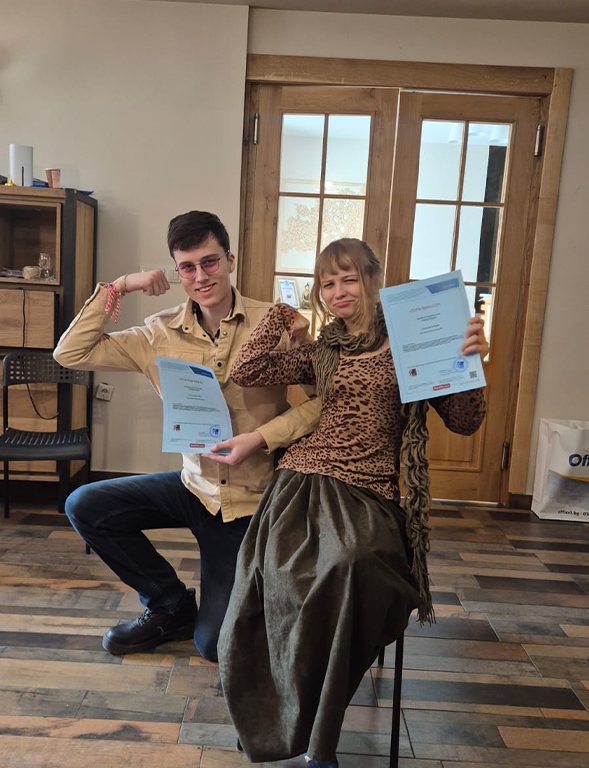 Two participants holding their certificates