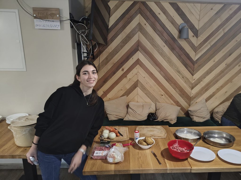 A participant smiling at a cooking station
