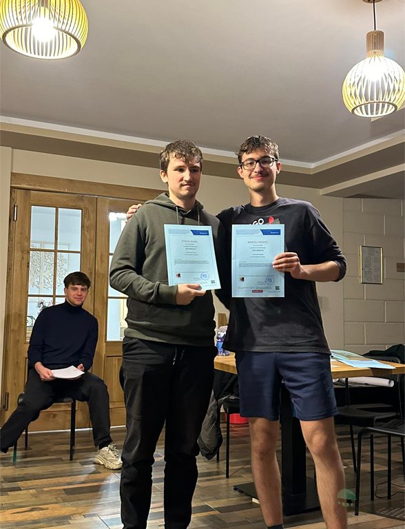 Two participants holding their certificates