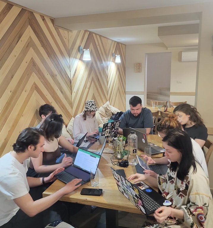 A team working on laptops at a shared table