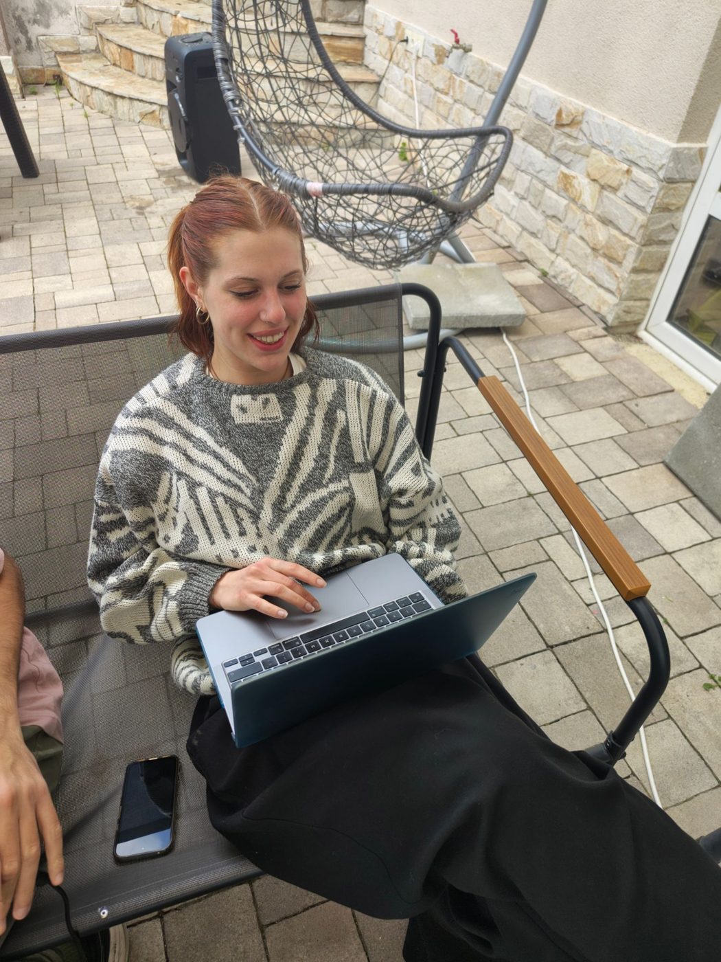 A participant works on a laptop outdoors on the terrace