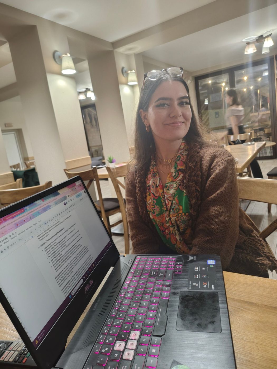 A participant smiles next to her laptop during an evening work session