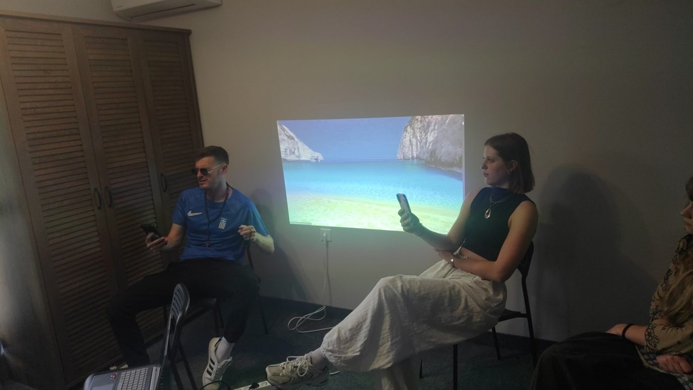 The Greek team presents their country, with a photo of a Greek beach on the wall